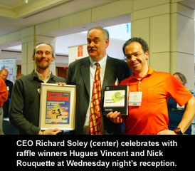 CEO Richard Soley (center) celebrates with raffle winners Hugues Vincent and Nick Rouquette at Wednesday night's reception
